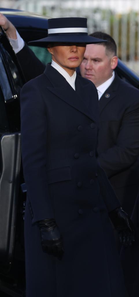 Melania Trump with a serious demeanor in a hat during the inauguration ceremony