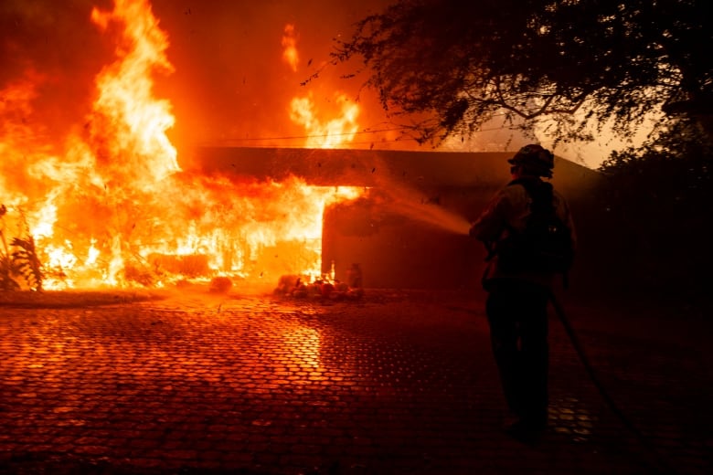 Burned vehicles and homes engulfed in flames during the Mountain Fire